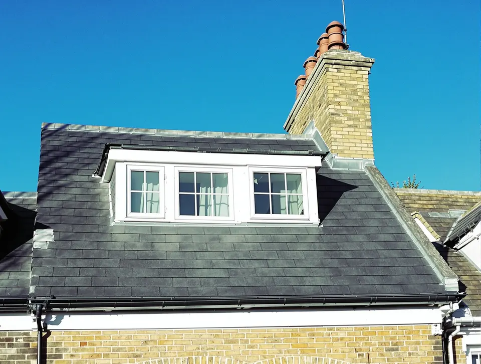 Completed mansard loft conversion exterior, slate cladding, three dormer windows, lead flashings.